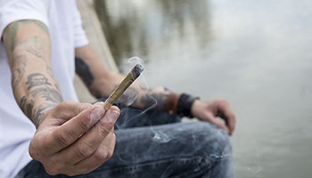 A man offering a cannabis cigarette